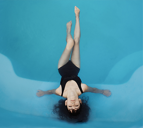 Women relaxing in the pool on her back