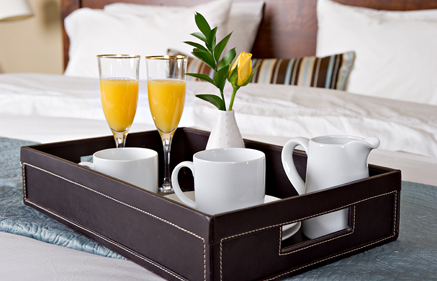 Room Service, cups and glasses in a tray placed on the bed