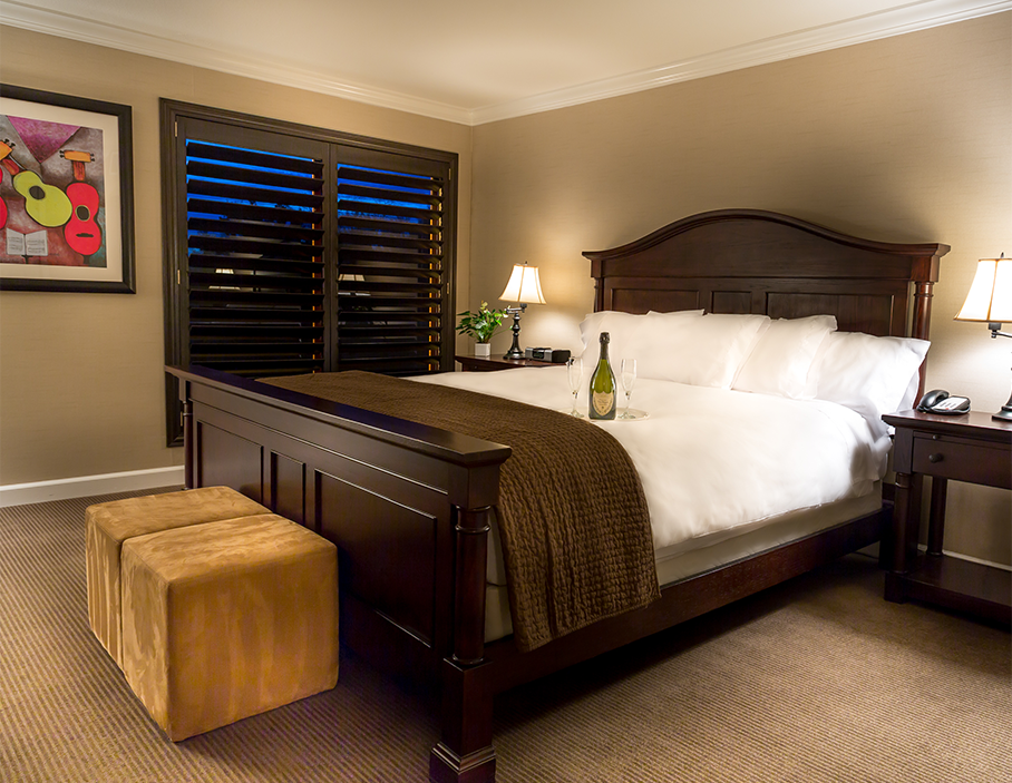 Suite with wine glasses and bottle in a tray placed on the bed